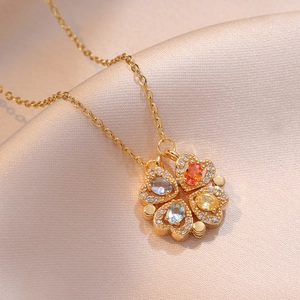 Gold clover heart necklace featuring colorful gemstone petals on silk background