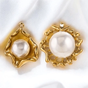 Detail of gold sunburst and wave pendants with white pearls on white silk background