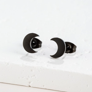 Détail des boucles d'oreilles lune en acier inoxydable noir mat sur socle en pierre