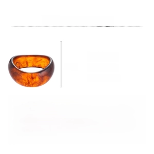 Macro detail of amber acrylic bangle showing marbled texture and 8cm diameter dimensions
