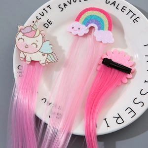 Close-up of rainbow hair extensions with unicorn, cloud and flower clips on a plate