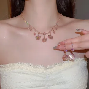 Close-up of pink zircon flower necklace and teardrop earrings set worn on neck