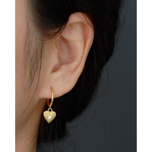 Vintage gold heart-shaped hoop earrings with sparkling white crystals on model