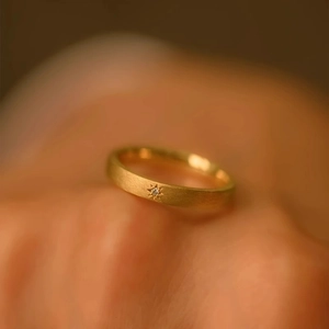 Macro shot of matte 18k gold plated ring featuring a star-shaped engraving with crystal
