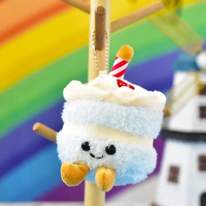 Close-up of a cute blue cake plush pendant with embroidered face and candle