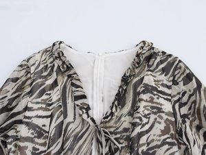 Close-up of zebra print chiffon dress showing V-neck ruffles and hidden back zipper
