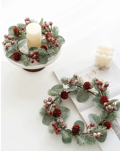 Makro-Detail von verschneitem Weihnachtskranz mit roten Beeren und Tannenzapfen Deko