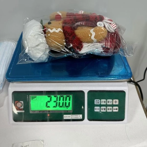Gingerbread man gnome plush toy in transparent packaging on a digital weighing scale