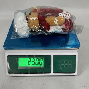 Gingerbread man gnome plush toy in transparent packaging on a digital weighing scale