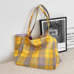 Macro shot of plaid tote bag featuring yellow and purple checkered canvas with lilac lining