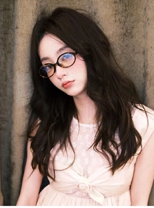 Close-up of tortoise shell oval frame glasses worn by a model in a retro Y2K style setting