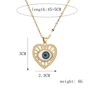 Detail of gold heart pendant with blue evil eye and white zircons on flat chain