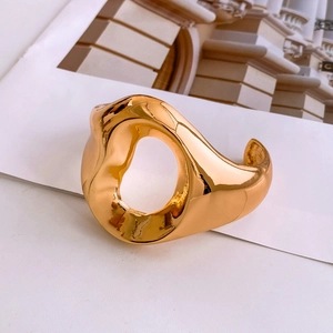 Detail of vintage gold textured wide cuff bracelet with artistic hollowed streamline design