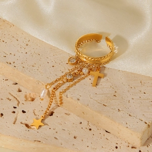 Detail of adjustable gold ring with star, cross, tassel chains and pearl pendants