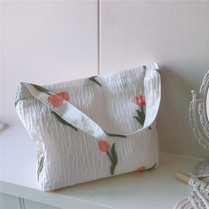 Gros plan sur la texture seersucker blanche avec élégante broderie de tulipes roses