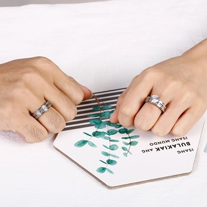Close-up of couples' ring set featuring a textured band and a round-cut solitaire ring