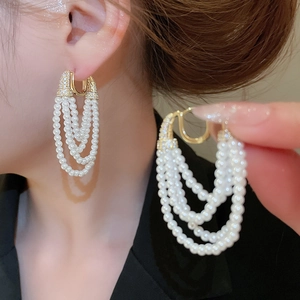 Détail des boucles d'oreilles à franges de perles multicouches avec fermoir doré en zircon