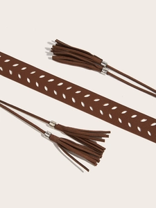 Close-up of brown suede belt featuring leaf cut-outs, decorative fringe, and silver buckle