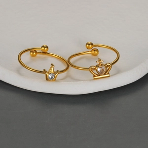 Elegant gold crown open rings with sparkling crystals on a minimalist display stand