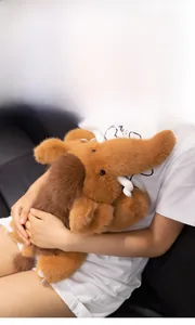 Close-up of a soft brown mammoth plush toy with fluffy fur and white curved tusks