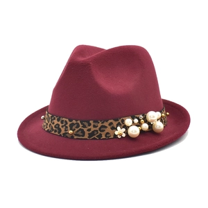 Detail of wine red wool fedora hat featuring leopard print band with pearls and floral accent