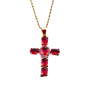 Gold cross necklace with five oval red zircons and pink diamond accents on white background