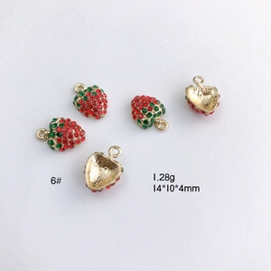 Macro view of 3D strawberry charm with red crystals, gold plating, and 14x10x4mm size