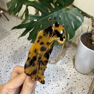 Detailed view of leopard-shaped hair claw clip with animal print pattern