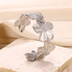 Detail shot of silver floral cuff bracelet with brushed texture on textured stone