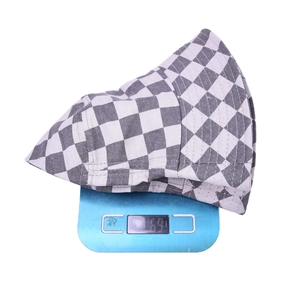 Détail montrant le chapeau bob à damier léger pesant 69g sur une balance de mesure