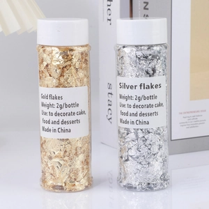 Macro shot of 2g gold and silver flakes in clear bottles for cake and nail art decoration