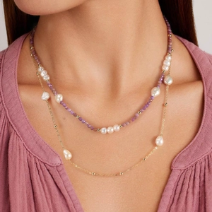 Detailed view of layered necklaces with freshwater pearls and amethyst colored beads