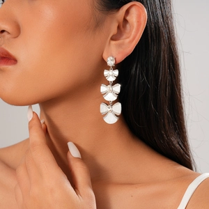 Elegant white shell bow-knot fan earrings with rhinestones on a professional model