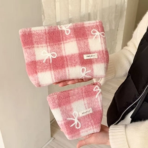 Close-up of pink and white checkered makeup bags with white bows in two sizes