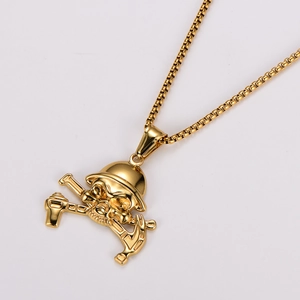 Macro detail of gold vintage skull pendant featuring a helmet and crossed wrenches design