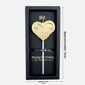 Dettaglio candela a cuore dorata con incisione Love e perla su scatola nera