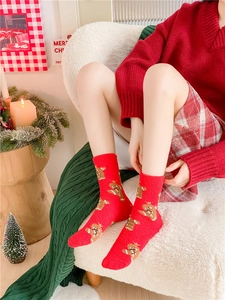 Gros plan de chaussettes de Noël rouges avec motif pain d'épices en molleton corail