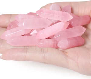Macro view of natural rose quartz double-pointed hexagonal pillars held in hand