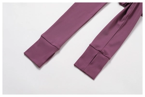 Détail du haut de yoga violet foncé avec poignets extensibles et trou pour le pouce