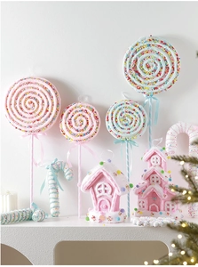Close-up of pastel lollipop and gingerbread house ornaments for Christmas tree decor