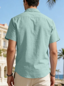 Men's mint green short sleeve linen shirt detail with turn-down collar against blue sky