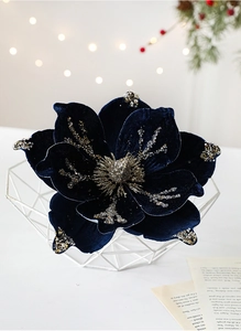 Close-up of deep blue velvet magnolia flower with gold glitter in a metal basket