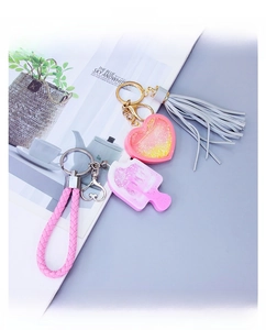 Detail of DIY resin heart and popsicle keychains with glitter, tassels and woven straps