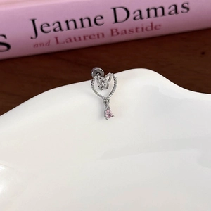 Close-up of pink pear-shaped drop earring with silver butterfly and heart frame detail