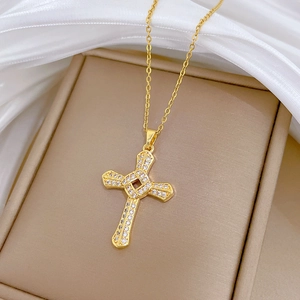 Rotating crystal cross necklace in gold finish displayed on a beige jewelry box