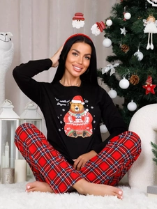 Detail of Christmas pajamas featuring a cute bear print with red plaid bottoms for home