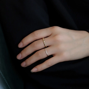 Minimalist geometric gold and silver ring set featuring elegant wavy texture on model hand