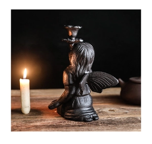 Detailed close-up of vintage cast iron fairy wings on a black candle holder