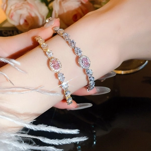 Detailed view of elegant gold and silver bracelets with pink oval-cut zircon gemstones