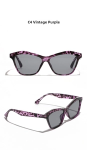 Detail view of vintage purple cat-eye sunglasses with tortoiseshell texture and grey lenses
